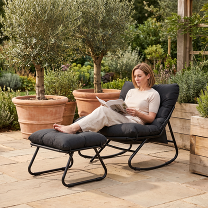 Woman relaxing, in The Tidewater Outdoor Rocker + Ottoman in a sunny stone patio