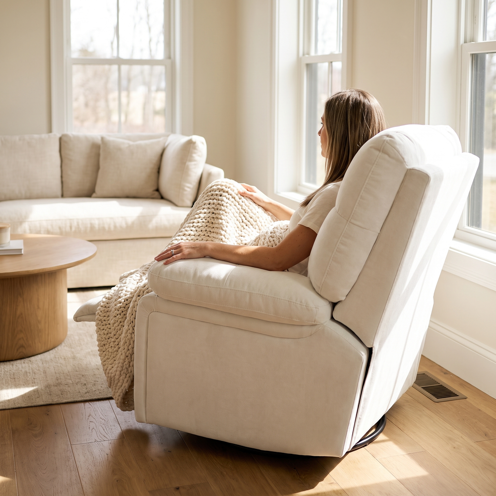 Woman relaxing, in The Solace Power Swivel Rocker Recliner, Heat + Massage in a sunny living room