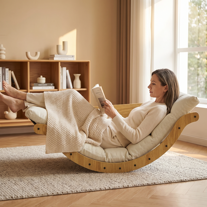 Woman reading, in The Crescent curved wood floor rocker in a sunlit living room