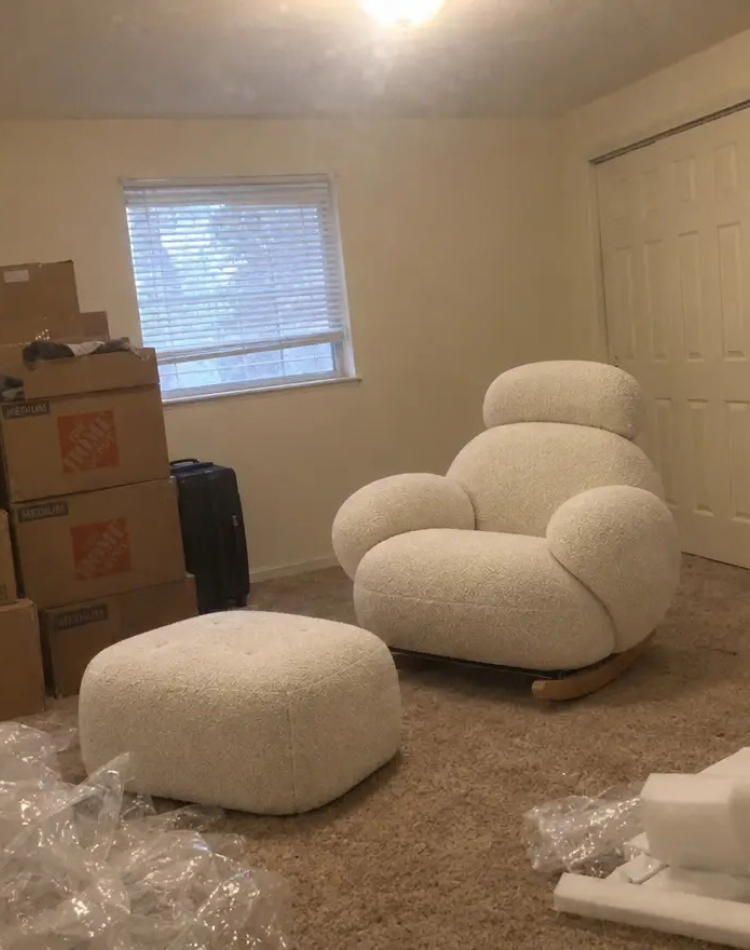 Cream boucle rocking chair and ottoman just unboxed in a bedroom