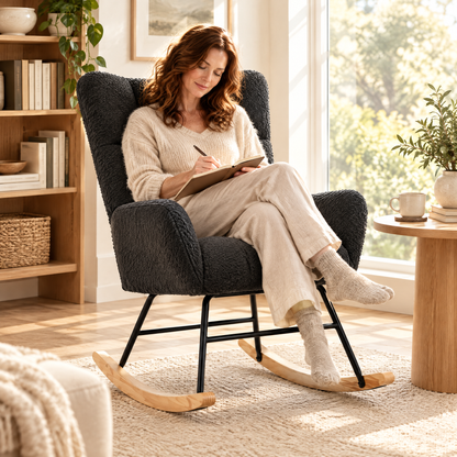 A woman with wavy auburn hair in her early 40s, writing in a journal, in The Winslow boucle wingback rocker in a sunlit reading corner